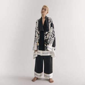 A model showcasing a stunning World Tree satin pajama set in black and white by Morgan & Tina.